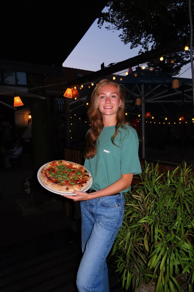 Gast met pizza op het terras bij Como